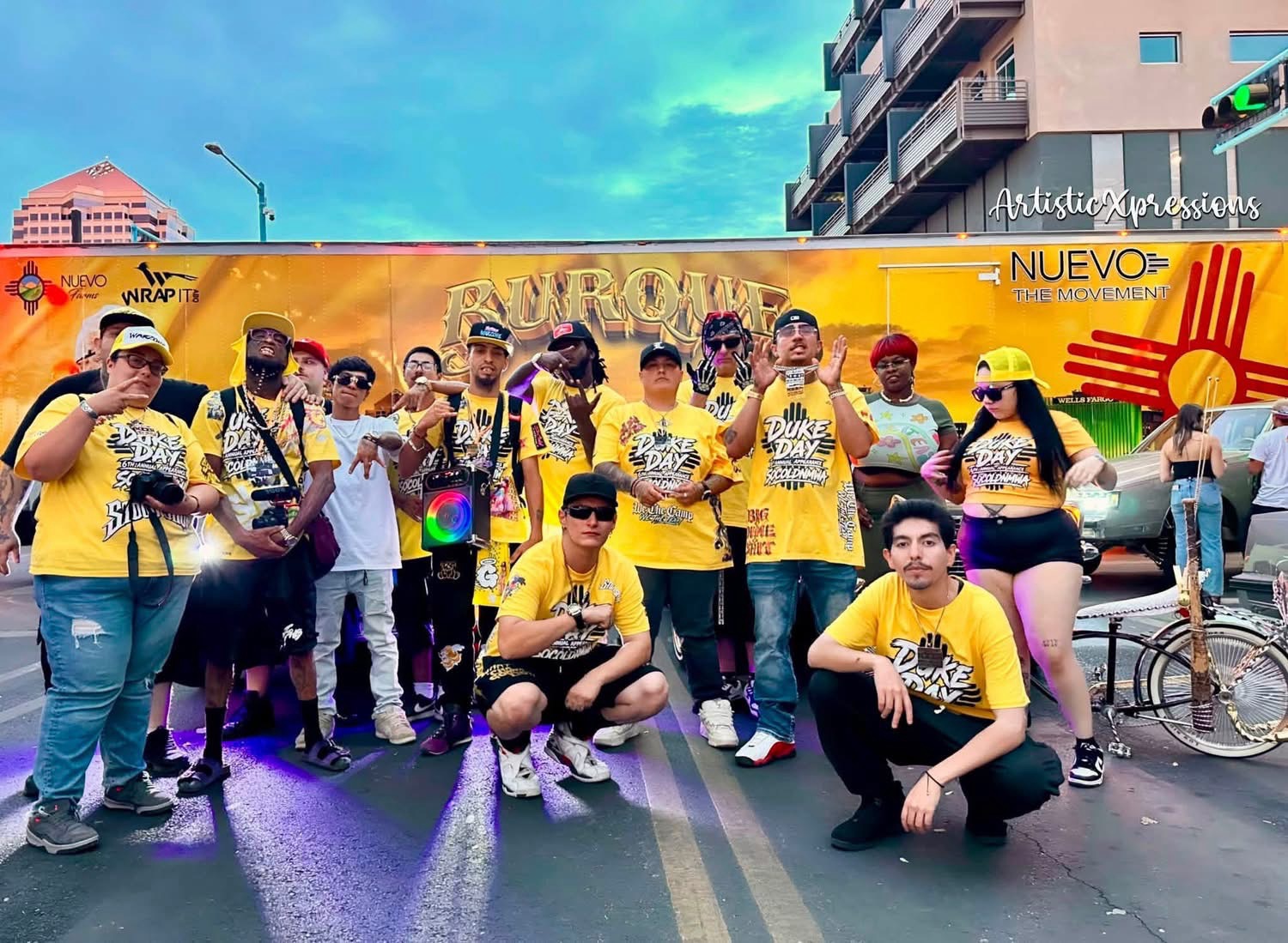Group photo in yellow Duke Day shirts in front of the Burque truck