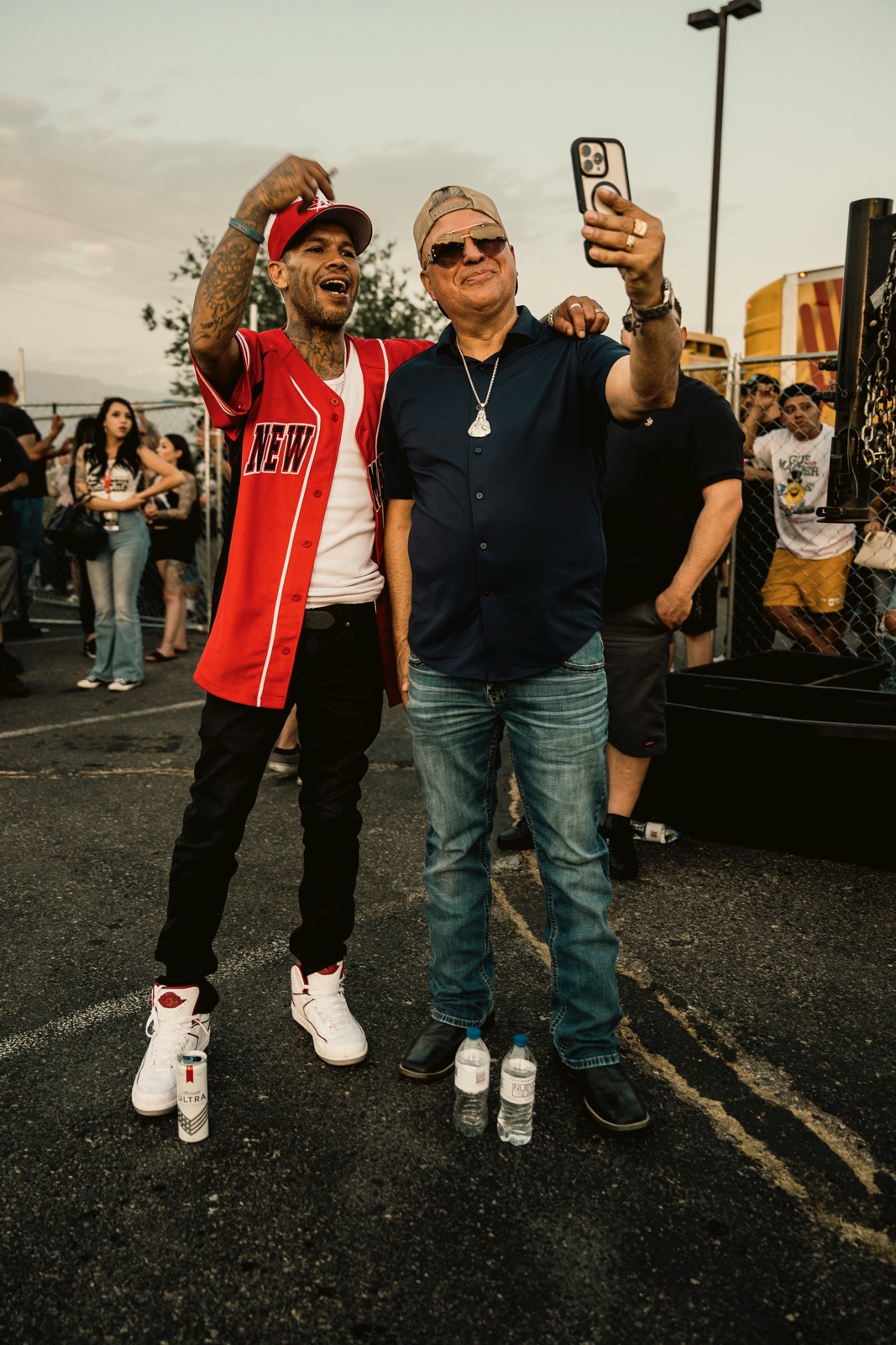 Two men taking a selfie together at an outdoor community event