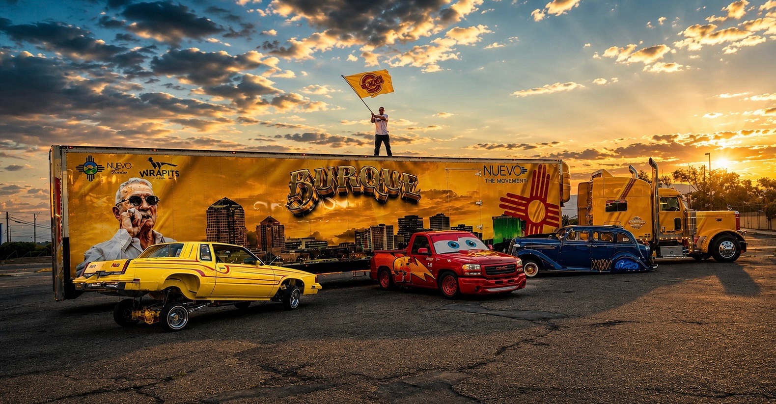 Man waving the New Mexico flag atop the Burque movement truck at sunset with classic cars